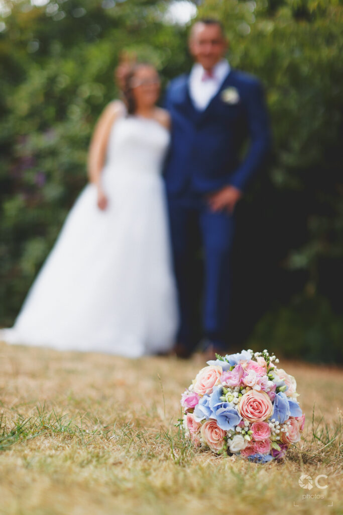 Photo de couple mettant en avant le bouquet de la mariée