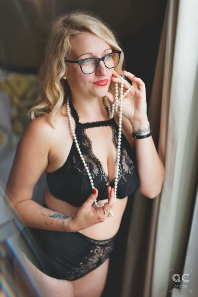 Femme en lingerie noire à côté de la fenêtre
