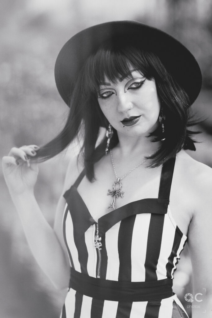 Portrait en noir et blanc d'une femme portant un chapeau noir et une robe rayée noir et blanc